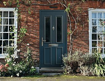 Smart Signature aluminium composite front door in dark blue with traditional panel design installed in a red brick home.